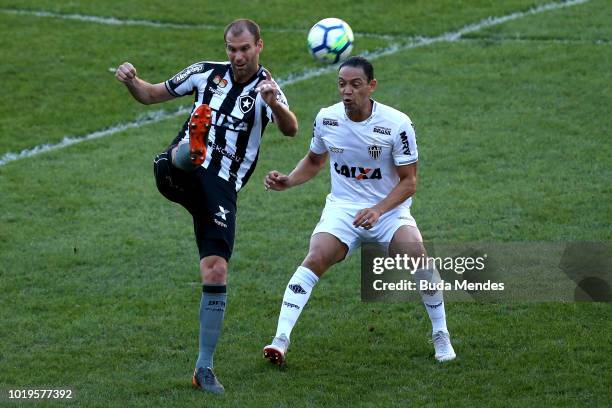 Joel Carli of Botafogo struggles for the ball with Ricardo Oliveira of Atletico during a match between Botafogo and Atletico MG as part of...