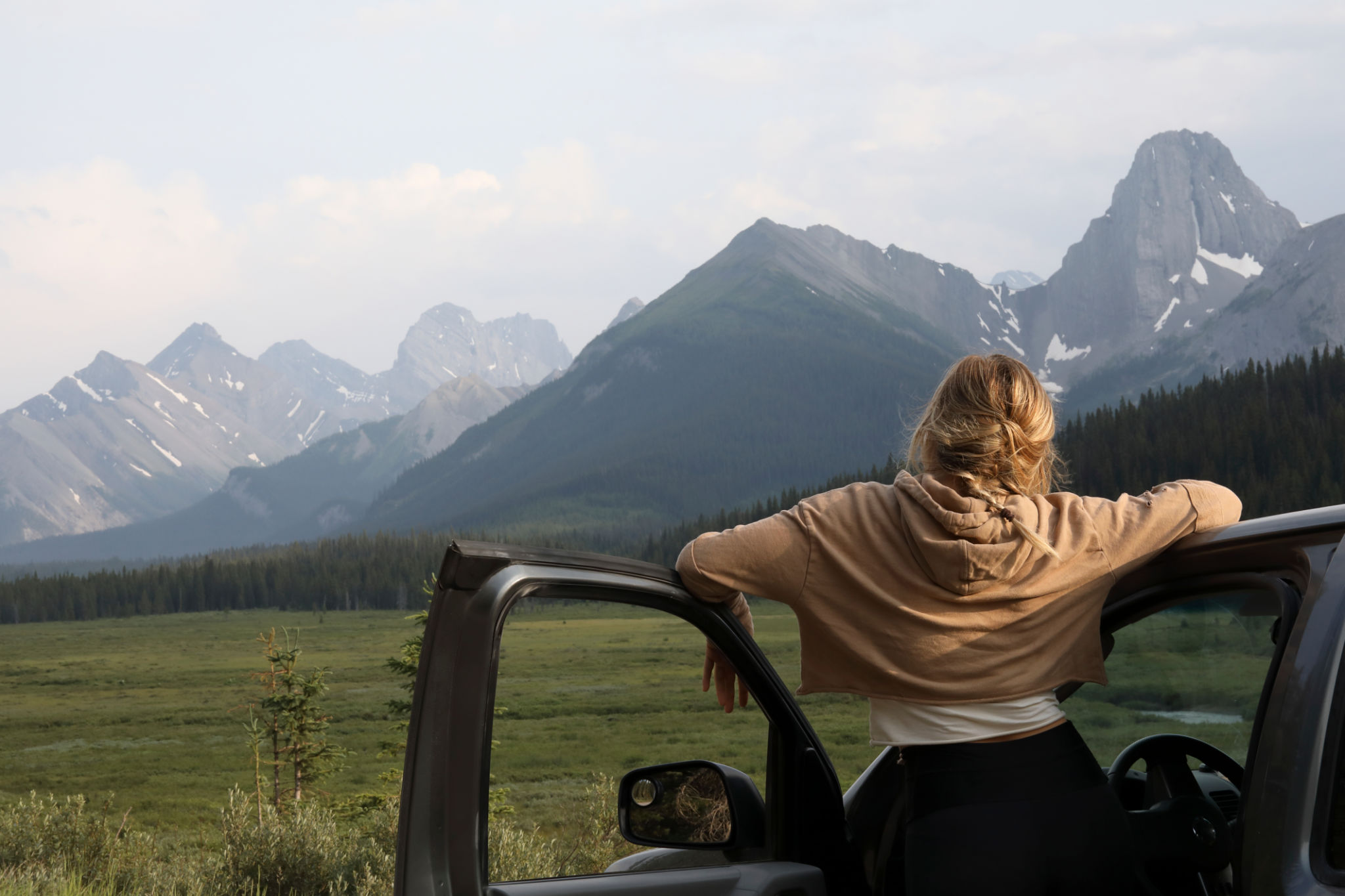 Young woman stops driving to relax and enjoy the view Young woman stops driving to relax and enjoy the view