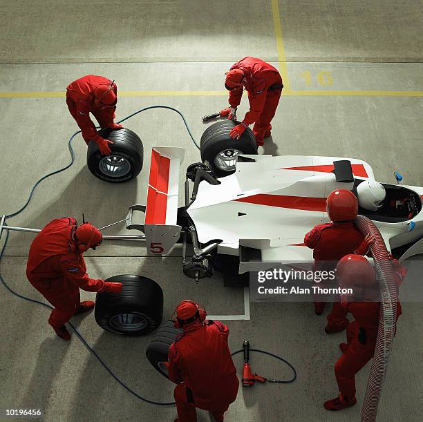 pit crew working on racing car, elevated view - aerodynamic stock-fotos und bilder