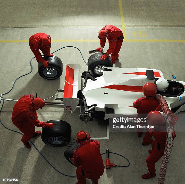 pit crew working on racing car, elevated view - pitstop team stock pictures, royalty-free photos & images