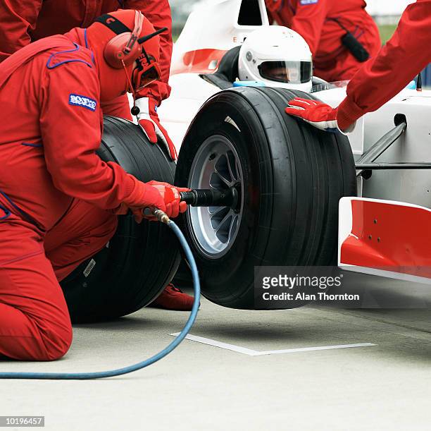 pit crew changing racing car wheel - pit stop stock pictures, royalty-free photos & images