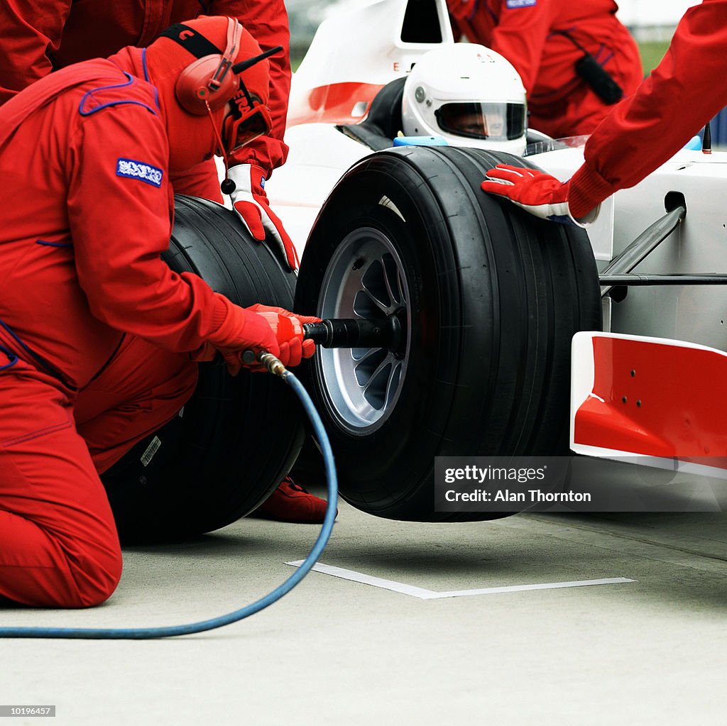 Pit crew changing racing car wheel