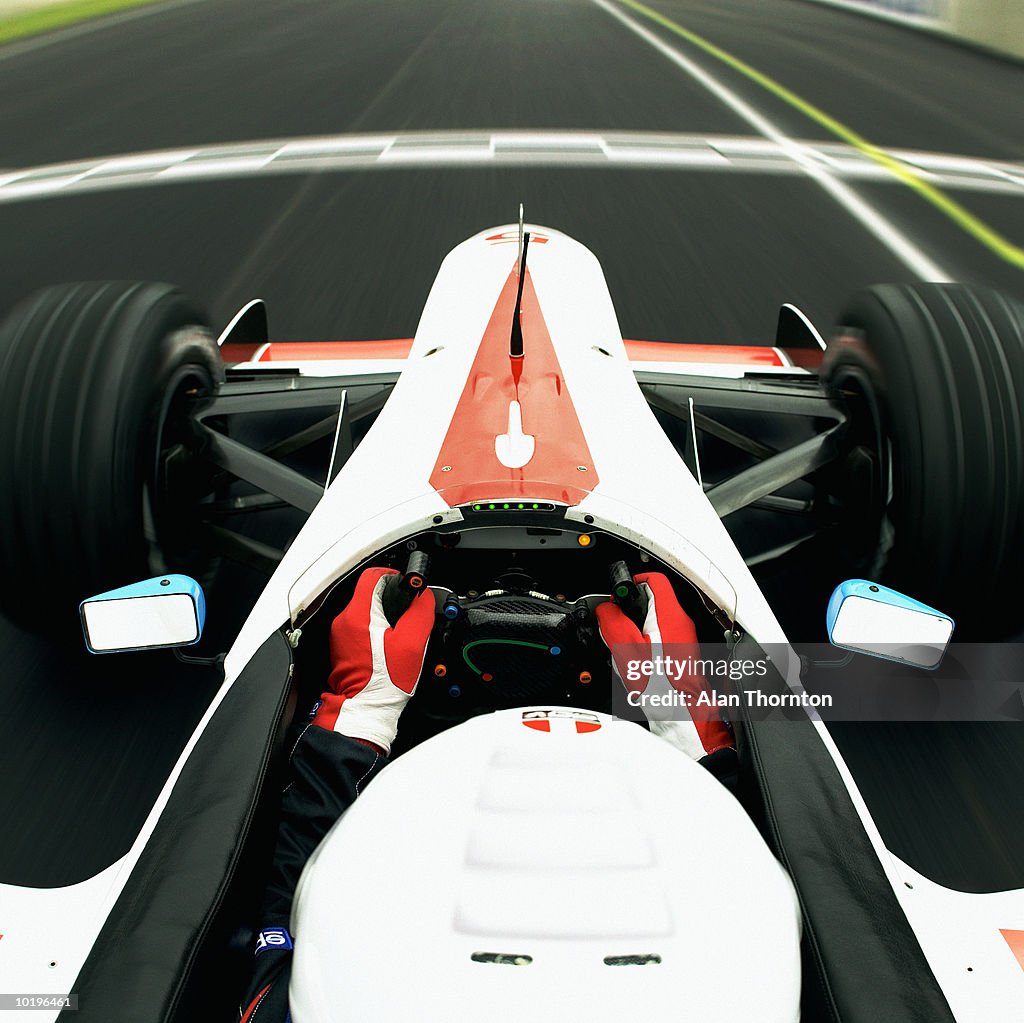 Racing driver approaching finishing line, view from behind driver