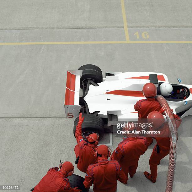 pit crew working on racing car, elevated view - pitstop team stock pictures, royalty-free photos & images