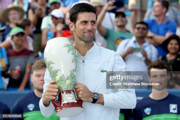 Novak Djokovic of Serbia poses with the winner's trophy after defeating Roger Federer of Switzerland during the men's final of the Western & Southern...