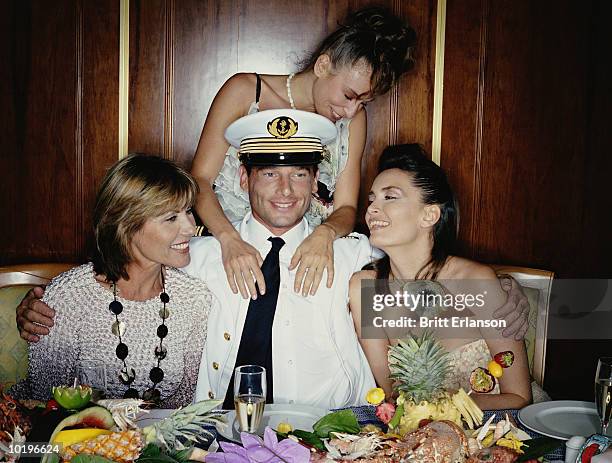 captain at table surrounded by three women, smiling - male with group of females stock pictures, royalty-free photos & images