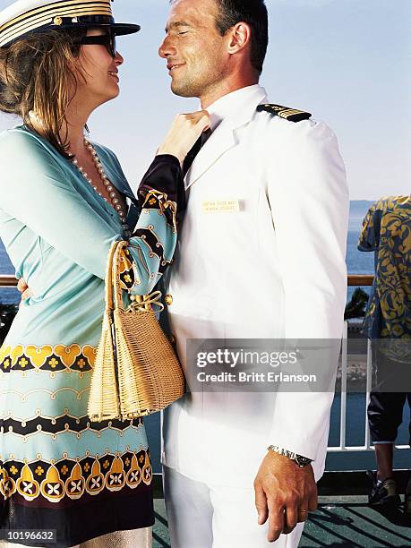 woman adjusting captain's tie on deck of cruise ship, close-up - cruise ship captain uniform stock pictures, royalty-free photos & images