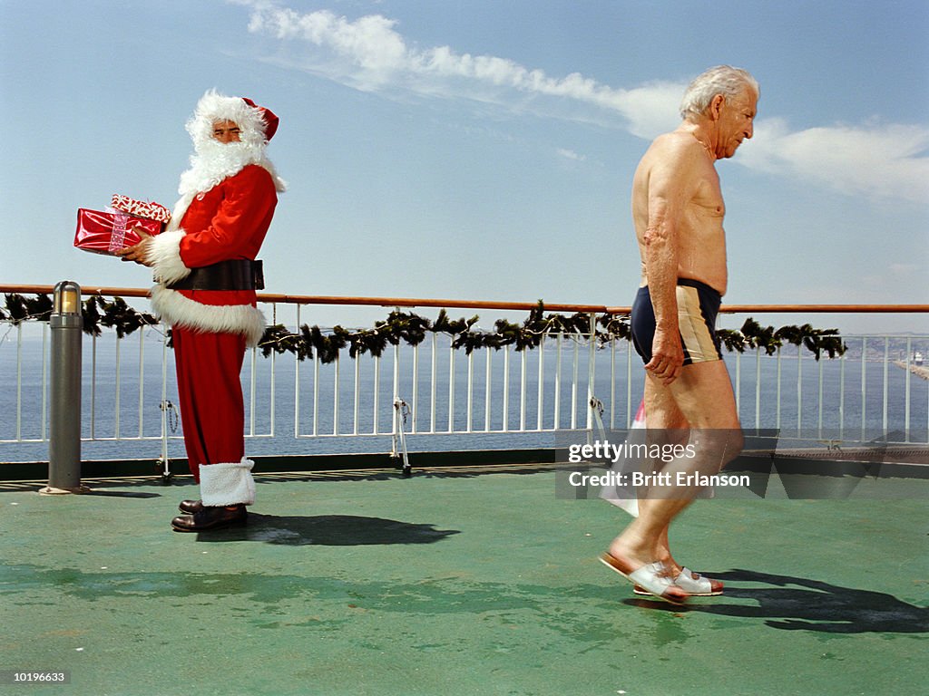 Two men on deck of cruise ship, one in Santa Claus costume