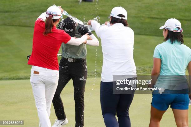 Golfer Sung Hyun Park has water poured on her by fellow players Jennifer Song in red and Amy Yang in white after she won on the 18th hole in a sudden...