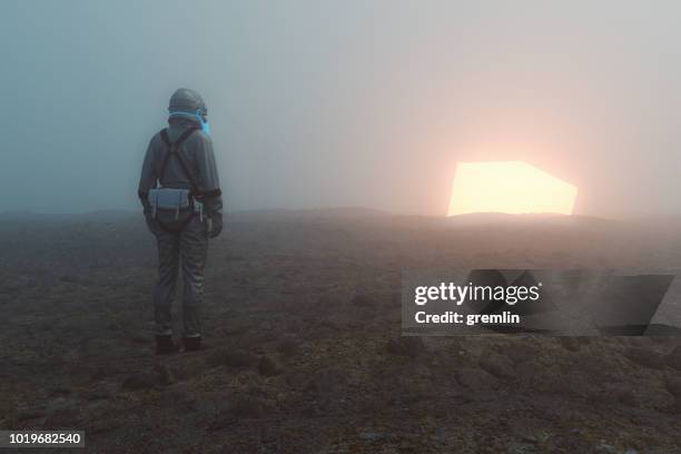 astronaut and glowing alien cube - glowing cube stock pictures, royalty-free photos & images