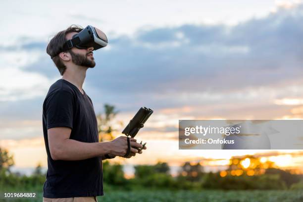 man flying a drone with virtual reality goggles headset - pilot simulator stock pictures, royalty-free photos & images