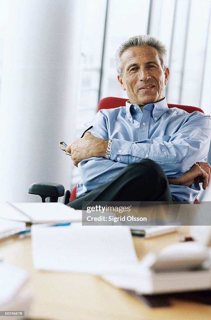 Mature male office worker relaxing in chair, portrait