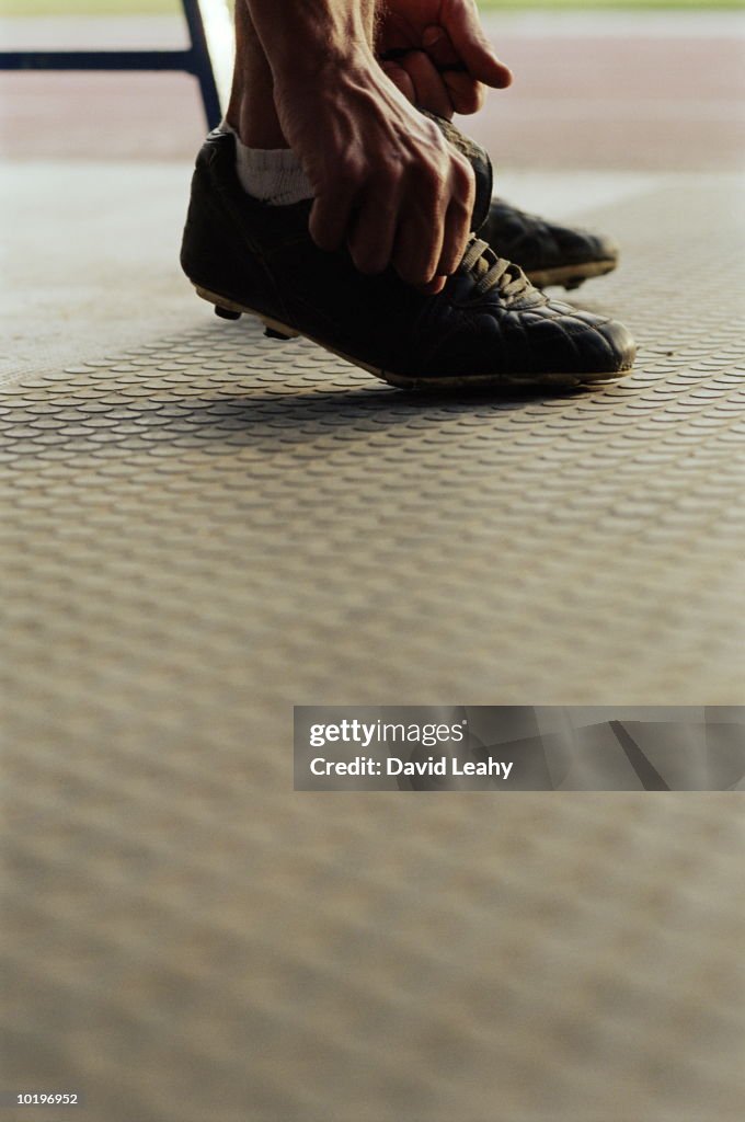 Footballer tying laces, low section