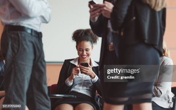 businesswoman text messaging in the office - overcrowded office meeting room stock pictures, royalty-free photos & images