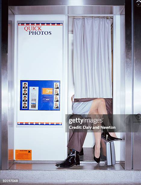 couple having picture taken in  booth, woman on man's lap - secluded couple stockfoto's en -beelden