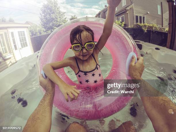 ze hebben veel plezier in het water met haar vader - girls in hot tub stockfoto's en -beelden