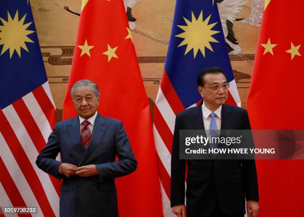 Malaysia's Prime Minister Mahathir Mohamad and China's Premier Li Keqiang arrive for a signing ceremony at the Great Hall of the People in Beijing on...