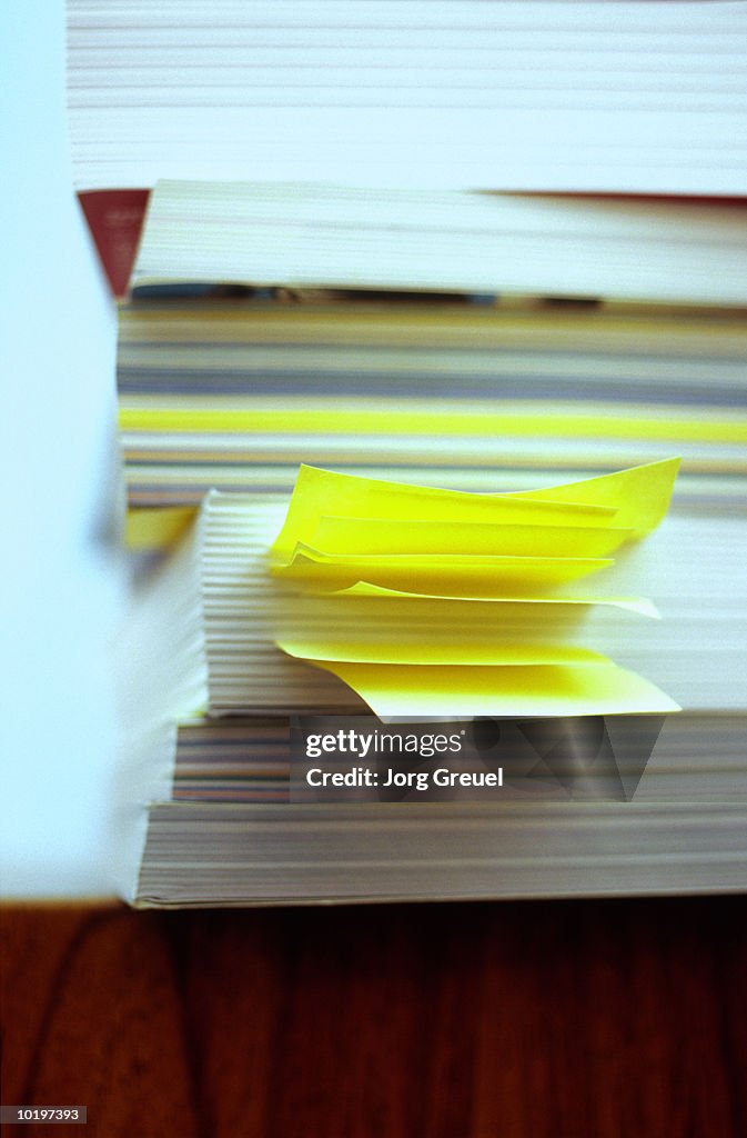 Pile of books, one with bookmarks sticking out, close-up