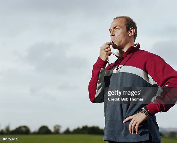 man blowing sports whistle - coach stock-fotos und bilder