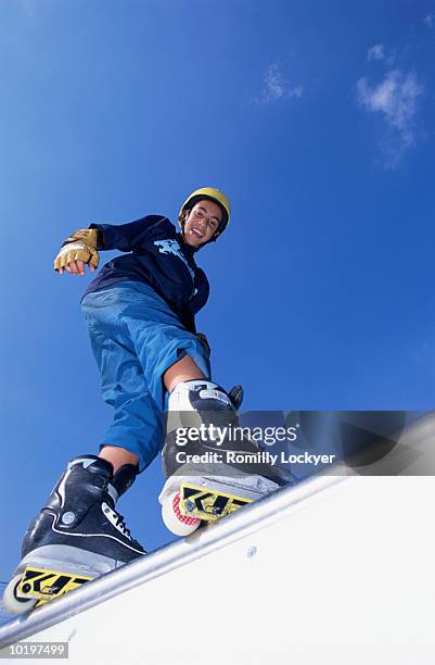 teeanage boy (13-15) on inline skating ramp, portrait, low angle view - blade stock pictures, royalty-free photos & images