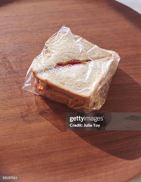 peanut butter and jelly sandwich in plastic wrap, close-up - peanut butter and jelly sandwich stock pictures, royalty-free photos & images