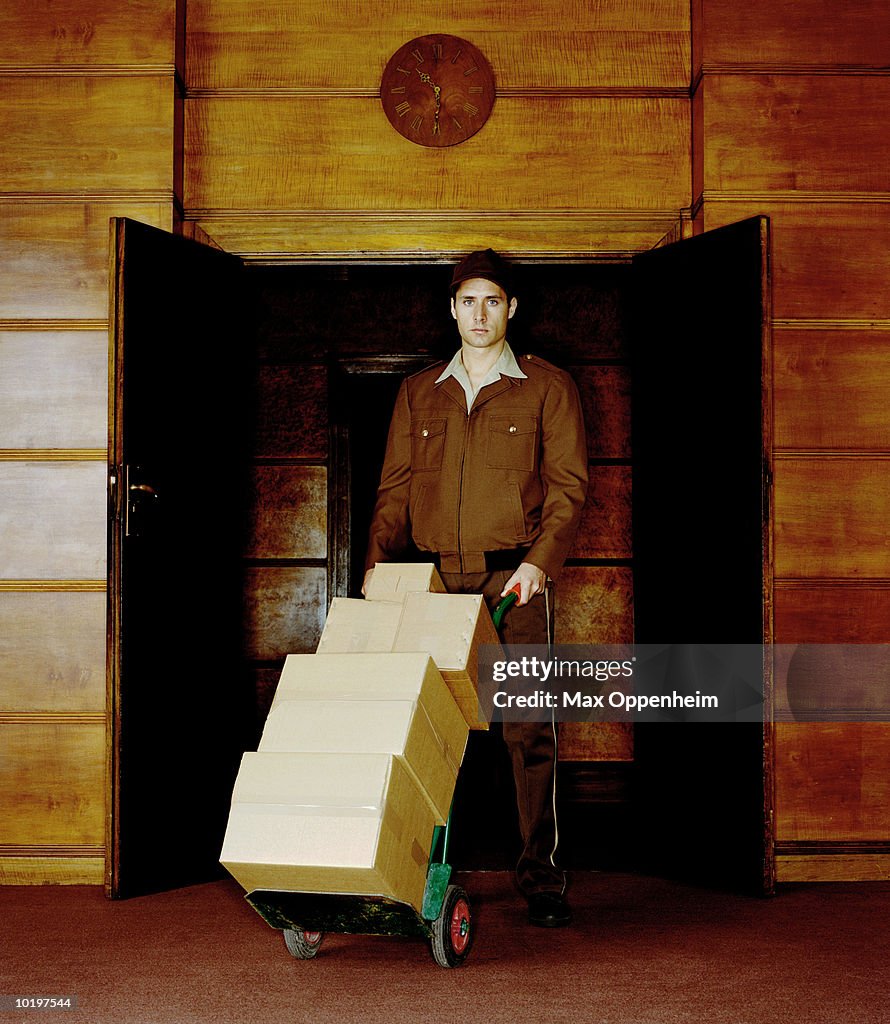 Parcel delivery man standing in doorway, portrait