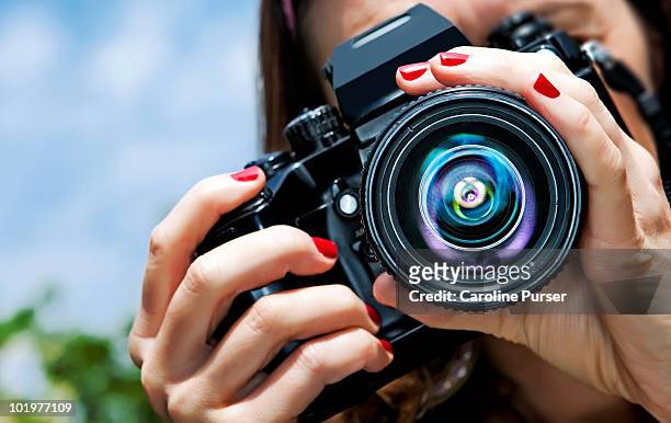 close up of a girl taking a picture (to camera) - photographer stock-fotos und bilder