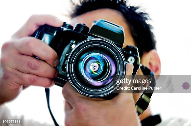 close up of a man taking a picture (to camera) - looking through lens stock pictures, royalty-free photos & images
