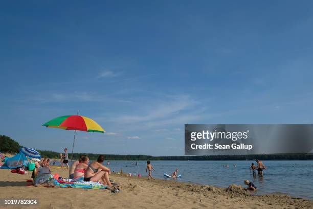 Bathers relax at a beach at Helenesee lake on August 19, 2018 near Franfurt an der Oder, Germany. Germany is experiencing a hot and dry summer, much...