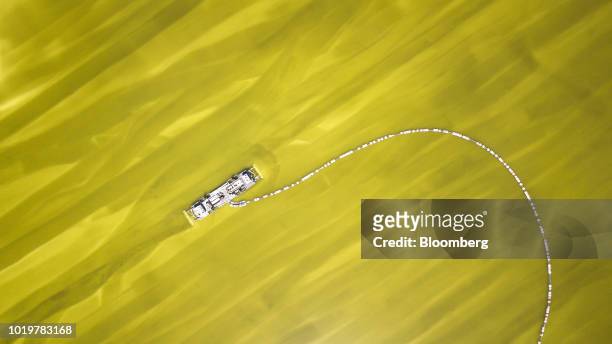 Barge pumps brine from an evaporation pond operated by Qinghai Salt Lake Industry Co. In this aerial photograph taken in Golmud, Qinghai province,...