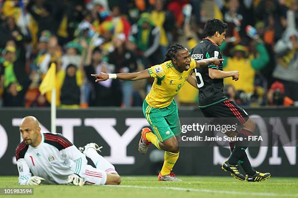Siphiwe Tshabalala of South Africa celebrates after scoring the opening goal while Ricardo Osorio and goalkeeper Oscar Perez of Mexico look dejected...