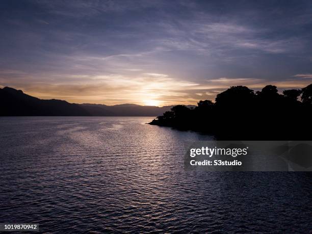 View of the Atitlan volcanoes is seen in the warm light of sunrise at the shores of Lake Atitlan on 12 August 2018, in the Solola department,...