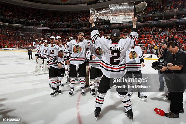 Duncan Keith of the Chicago Blackhawks hoists the Stanley Cup after teammate Patrick Kane scored the game-winning goal in overtime to defeat the...