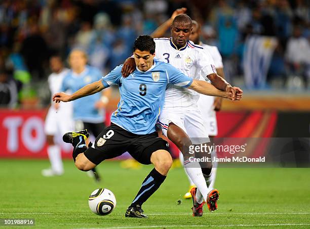 Eric Abidal of France challenges Luis Suarez of Uruguay during the 2010 FIFA World Cup South Africa Group A match between Uruguay and France at Green...