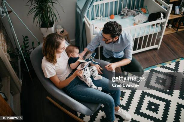 parents playing with their baby - rocking chair stock pictures, royalty-free photos & images