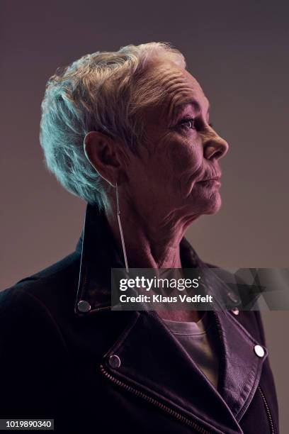 profile portrait of cool mature woman, with coloured lights - portrait profile stock-fotos und bilder