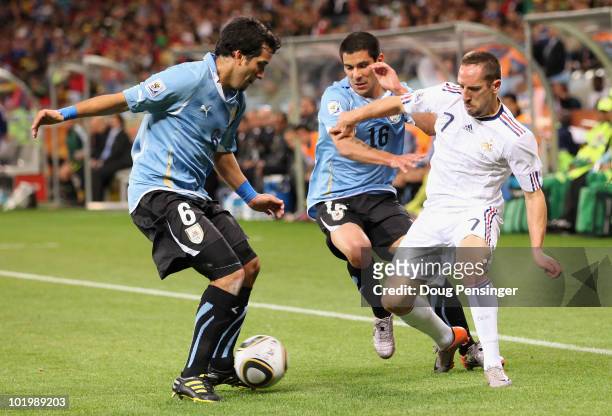 Franck Ribery of France is closed down by Mauricio Victorino and Maximiliano Pereira of Uruguay during the 2010 FIFA World Cup South Africa Group A...