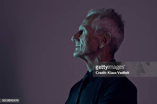 profile portrait of cool mature man, with coloured lights - mann optimistisch stock-fotos und bilder