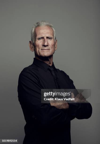 portrait of cool mature man looking in camera - folded arms stockfoto's en -beelden