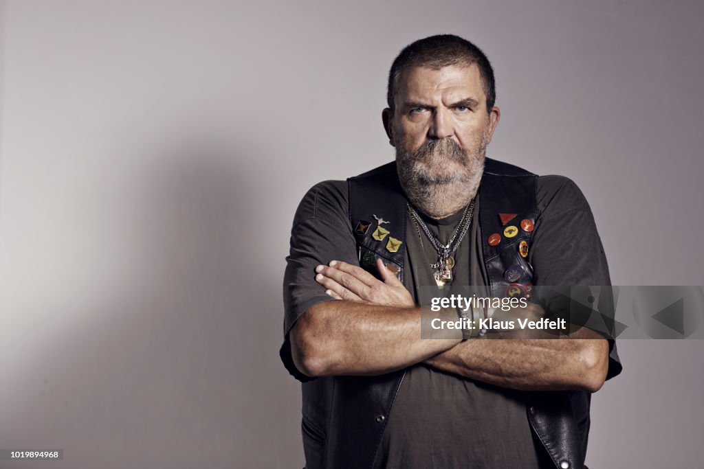 Mature rough looking man photographed on studio with hard lighting