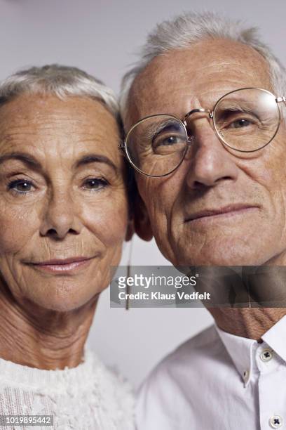 cool senior couple looking in camera - couples studio portrait stock-fotos und bilder