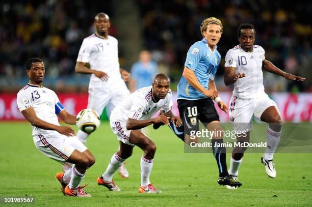 Diego Forlan of Uruguay comes under pressure from Patrice Evra , Eric Abidal and Sidney Govou of France during the 2010 FIFA World Cup South Africa...