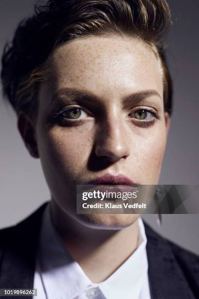 portrait of beautiful non-binary person looking in camera, shot on studio - groene ogen stockfoto's en -beelden