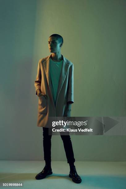 beautiful young man looking out, shot on studio - green coat 個照片及圖片檔