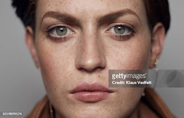 close-up portrait of beautiful young woman looking in camera, shot on studio - portrait stock-fotos und bilder