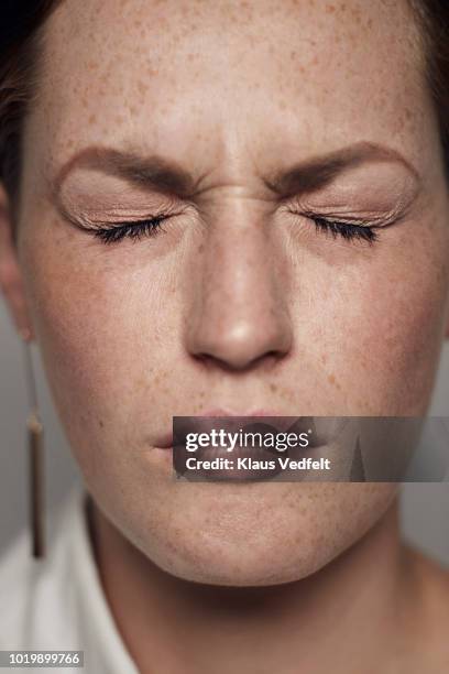 portrait of beautiful young woman squinting, shot on studio - tender imagens e fotografias de stock