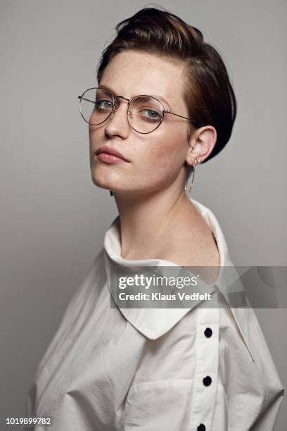 portrait of beautiful young woman wearing glasses & looking in camera - 2018 glasses stockfoto's en -beelden