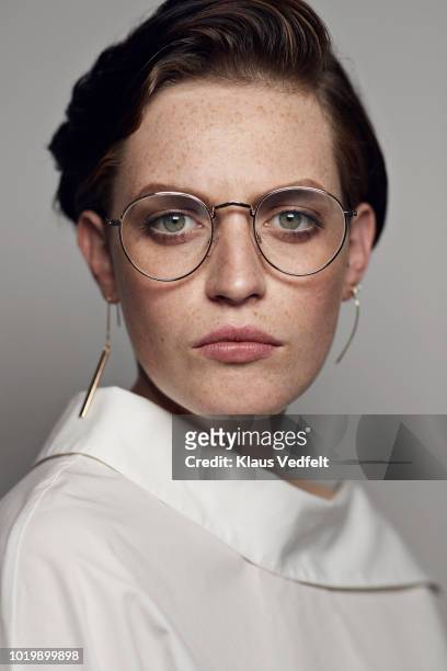 portrait of beautiful young woman wearing glasses & looking in camera - fashion photography stock-fotos und bilder