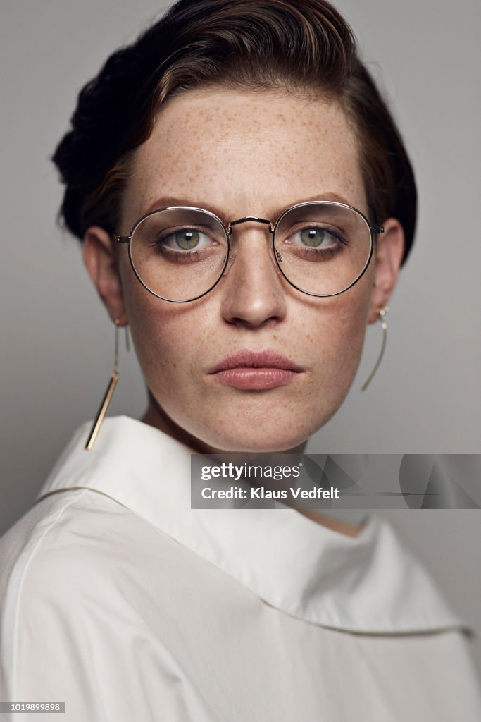 Portrait of beautiful young woman wearing glasses & looking in camera