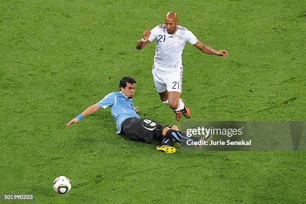 Nicolas Anelka of France jumps over the challenge by Mauricio Victorino of Uruguay during the 2010 FIFA World Cup South Africa Group A match between...